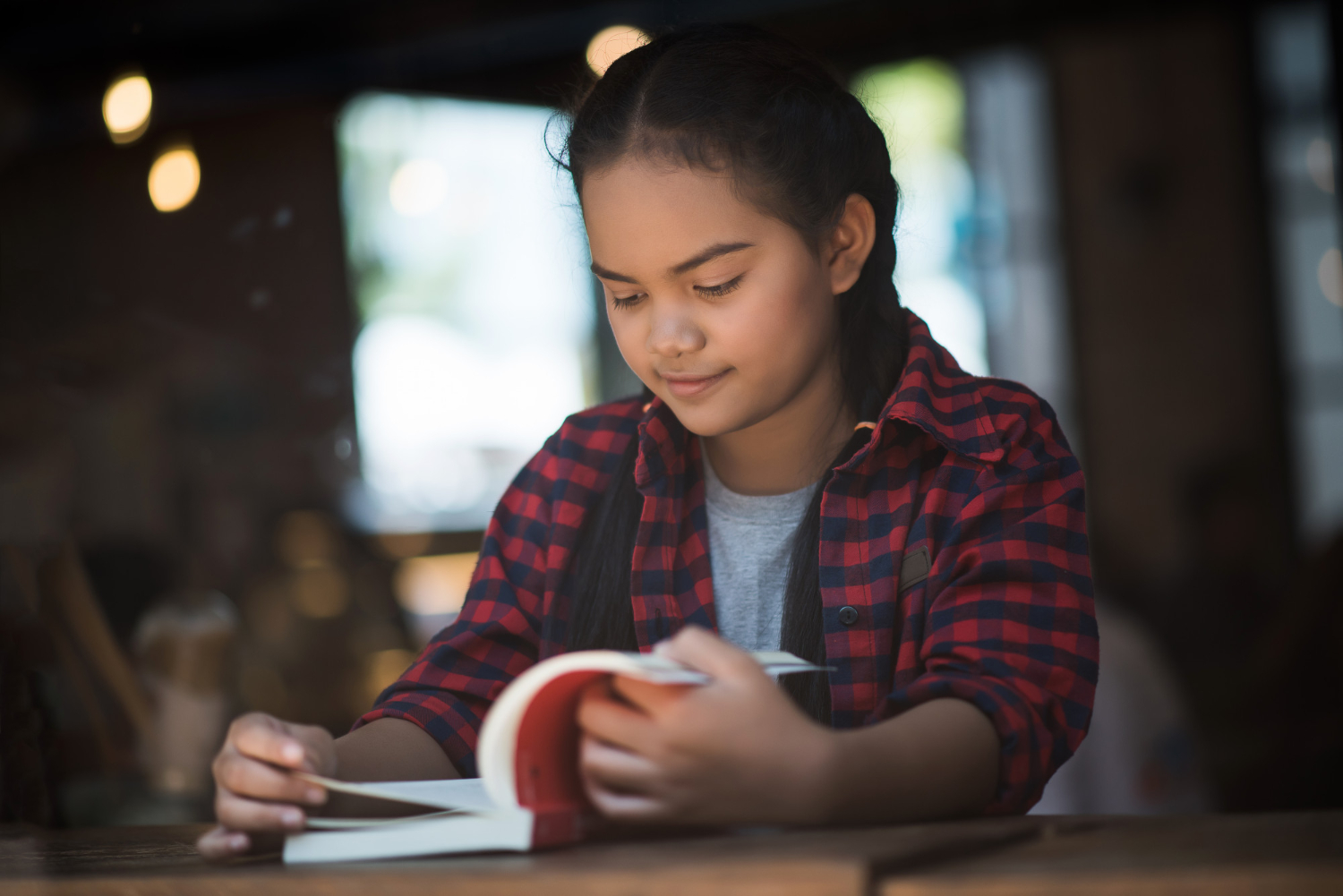 young-woman-reading-book-sitting-indoor-urban-cafe.jpg